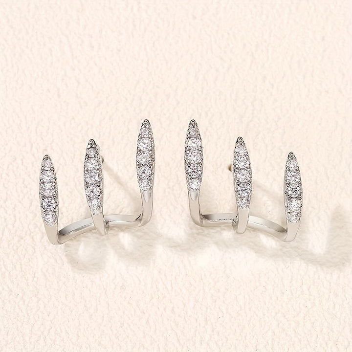 Elegantiškos auskarai su kristalais, laikomi trimis grifais